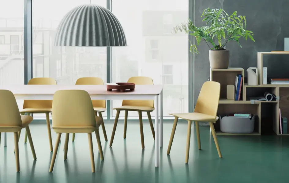 Modern zöld munkahely természetes fénnyel, ergonomikus fenntartható irodabútorral, növényekkel és multifunkcionális, rugalmasan alakítható terekkel.